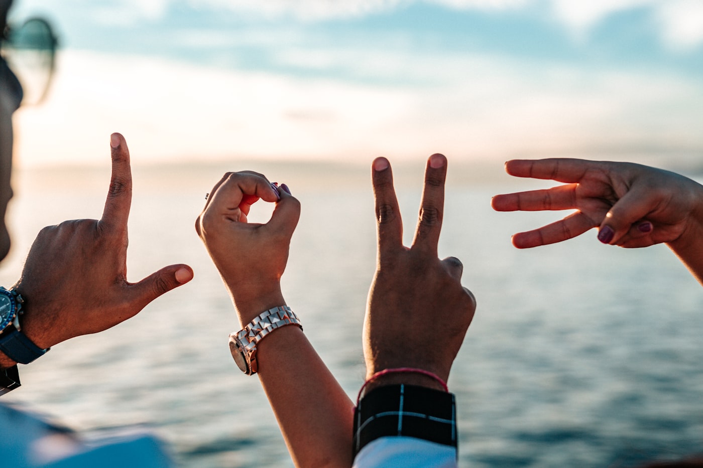Example HD memory film still — hands spelling LOVE at sunset