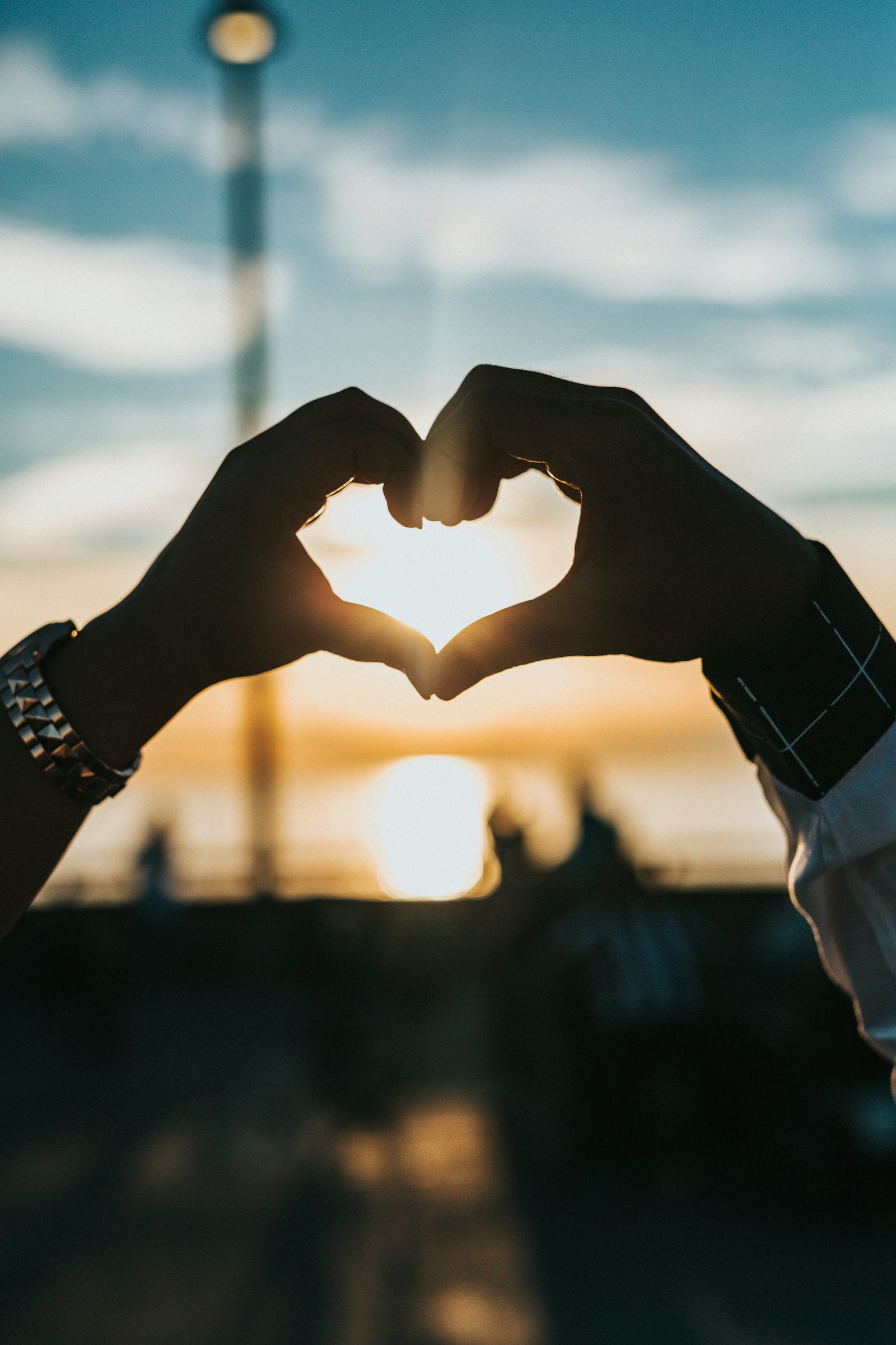 Two hands forming a heart around a sunset — a private memory worth keeping